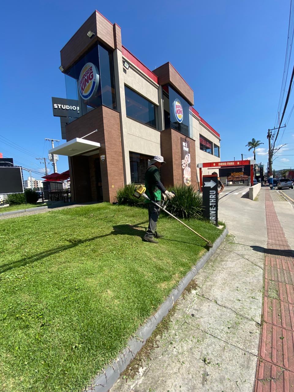 Equipe Confia Lar executando manutenção de gramado em cliente corporativo