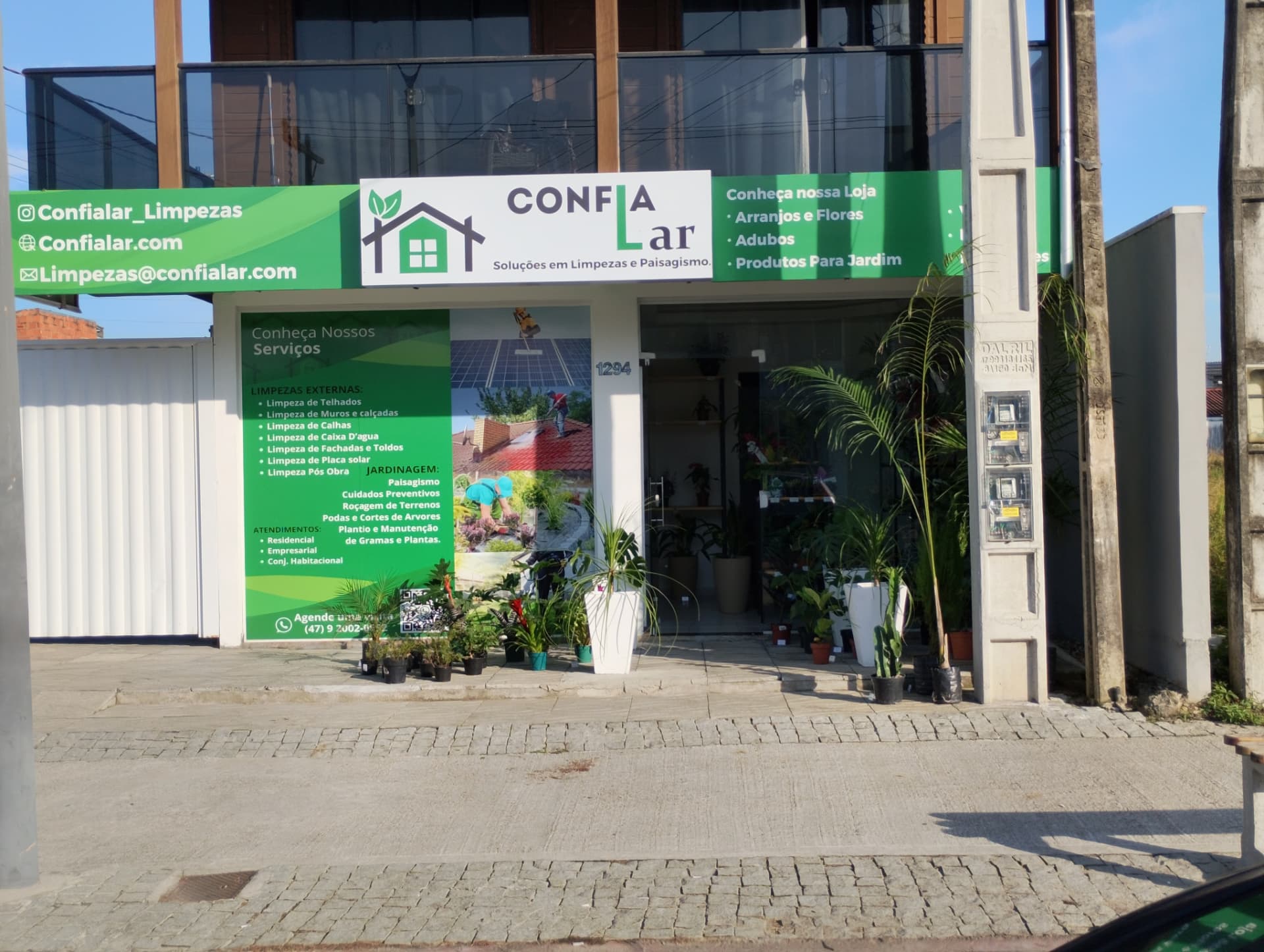 Fachada da loja Confia Lar com plantas e produtos para jardim